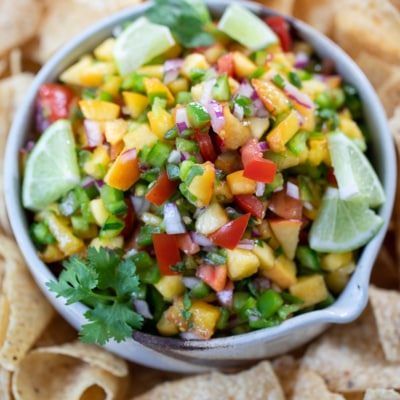 Spicy Peach Salsa in a bowl with tortilla chips.