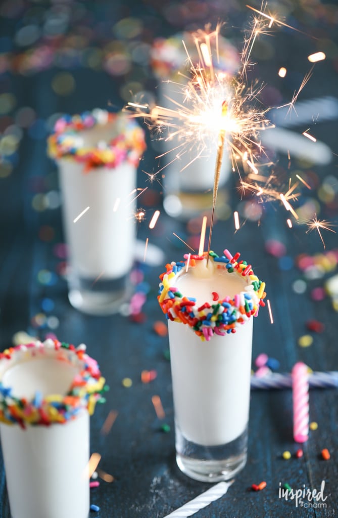 shot glass rimmed with sprinkles filled with a birthday cake flavored shot. 