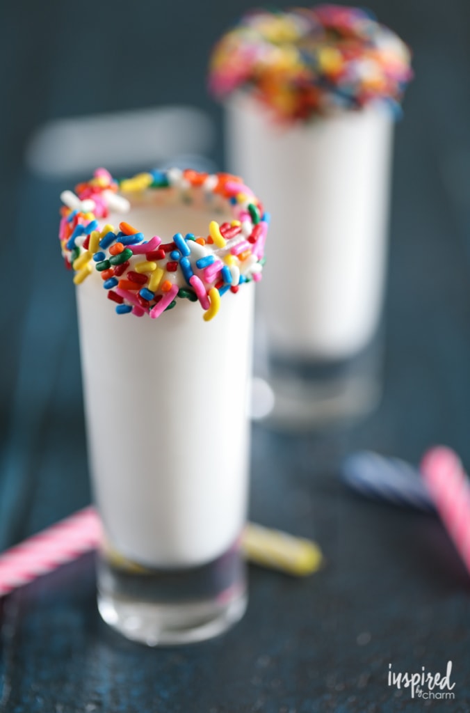 shot glass rimmed with sprinkles filled with a birthday cake flavored shot. 