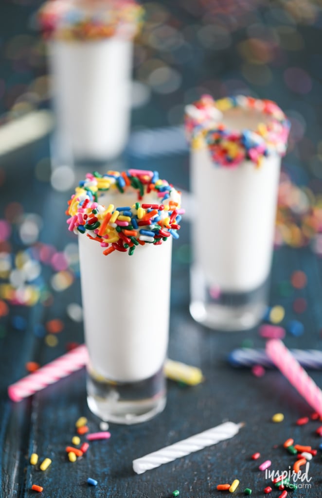 shot glass rimmed with sprinkles filled with a birthday cake flavored shot. 