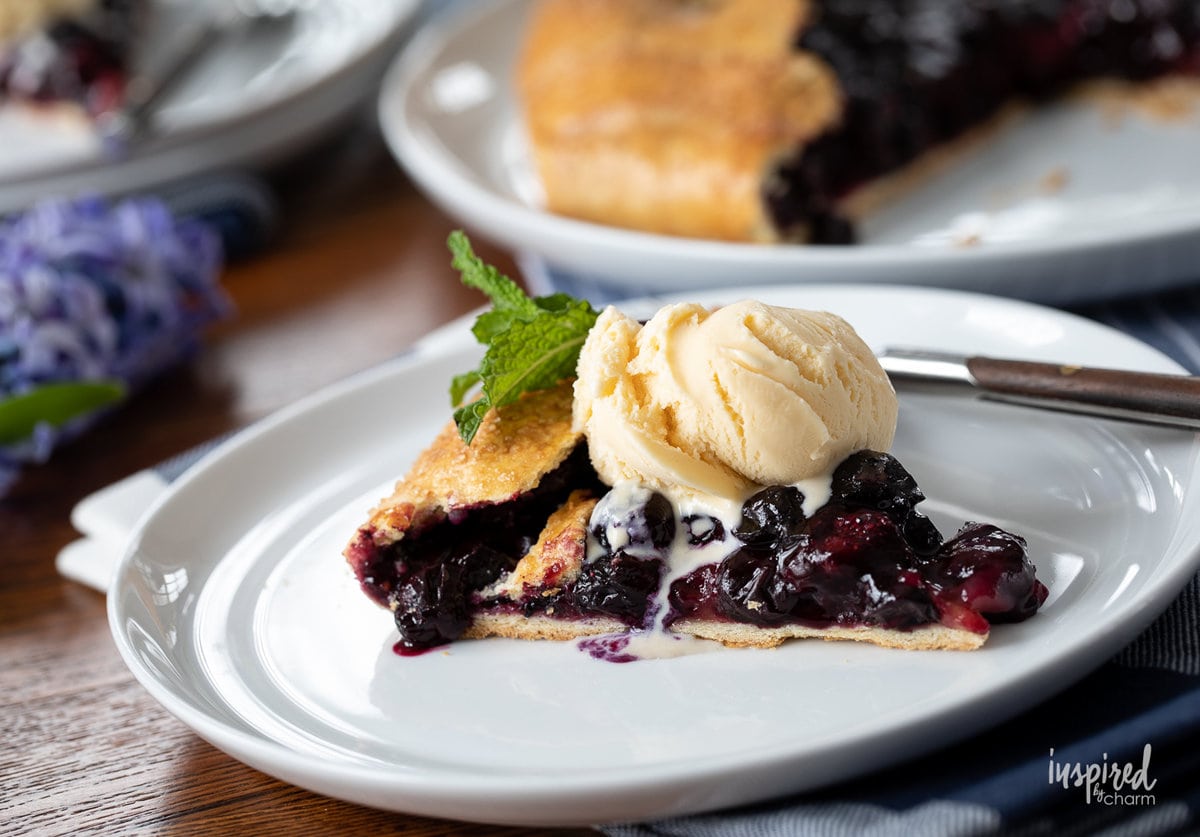 slice of blueberry galette with ice cream on a plate.