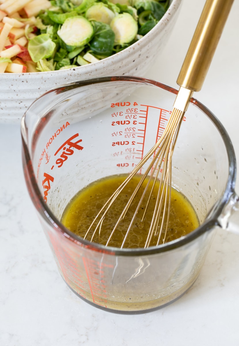 dressing for Shaved Brussels Sprout Salad in a glass measuring cup.