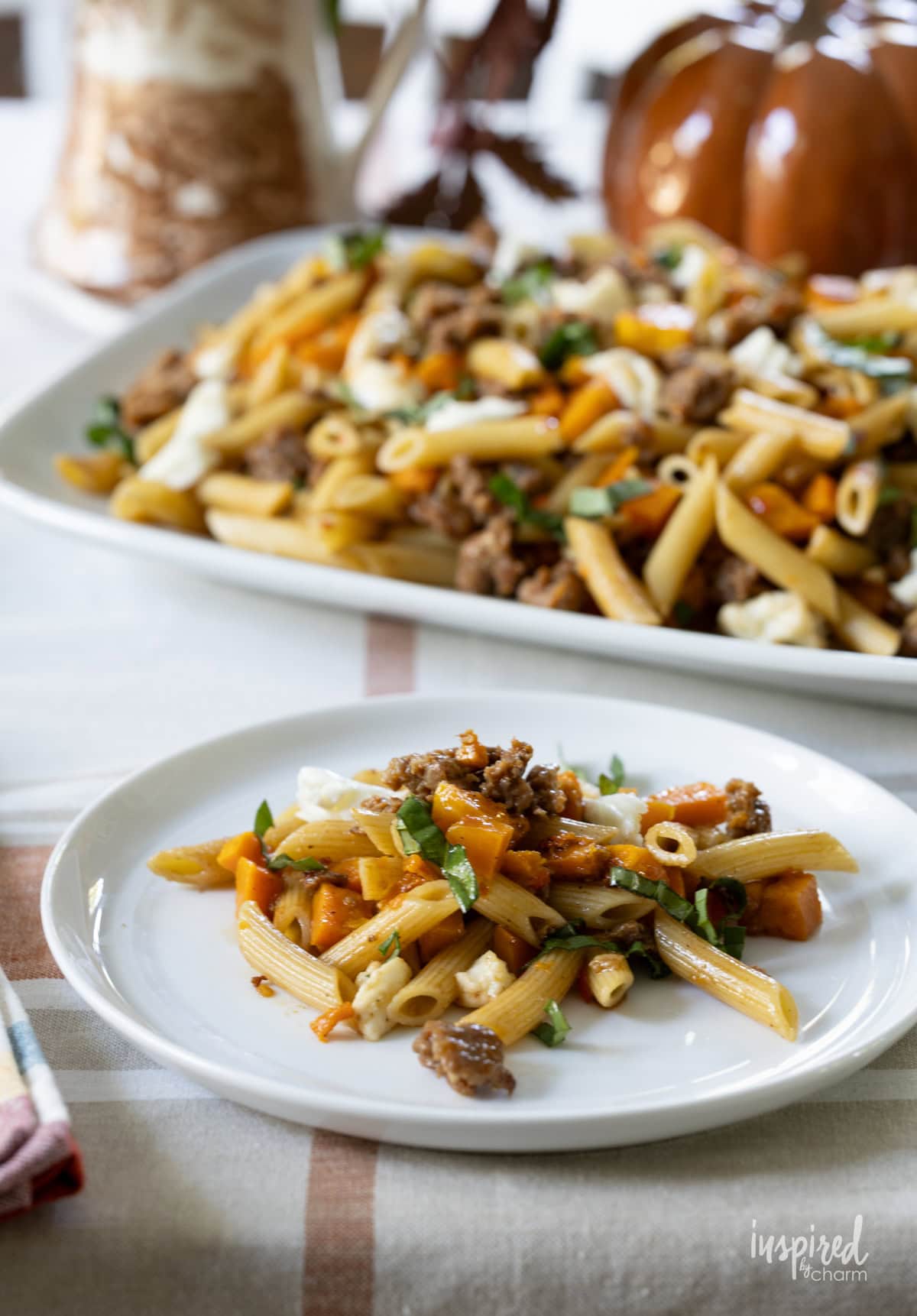 Butternut Squash and Sausage Pasta on a platter and served on a small plate.