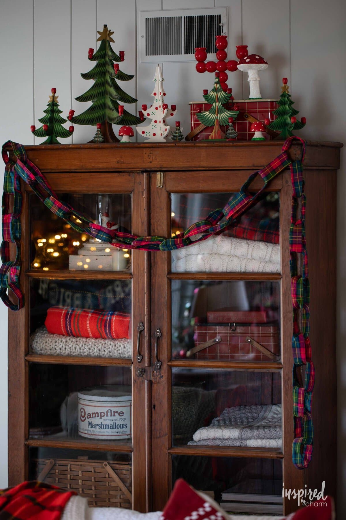 wood cabinet with vintage Christmas decor on top.