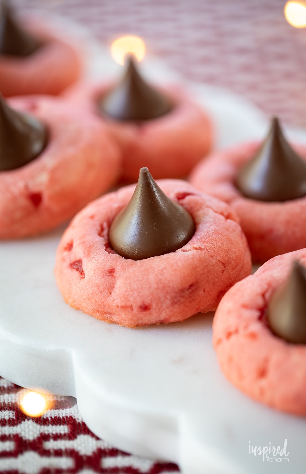 cherry blossom cookies stacked on a small white plate.