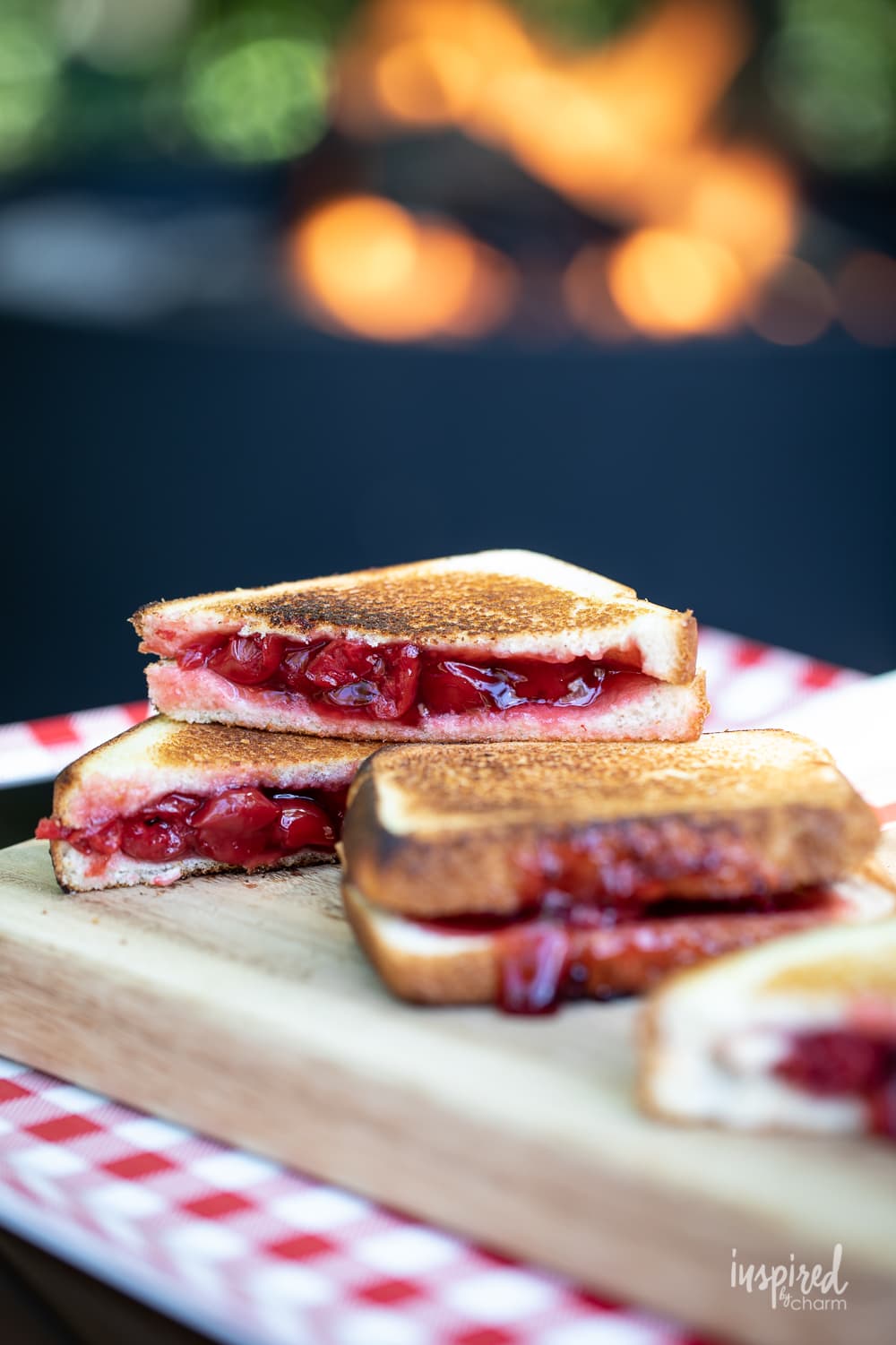 cherry mountain pies stacked on cutting board.