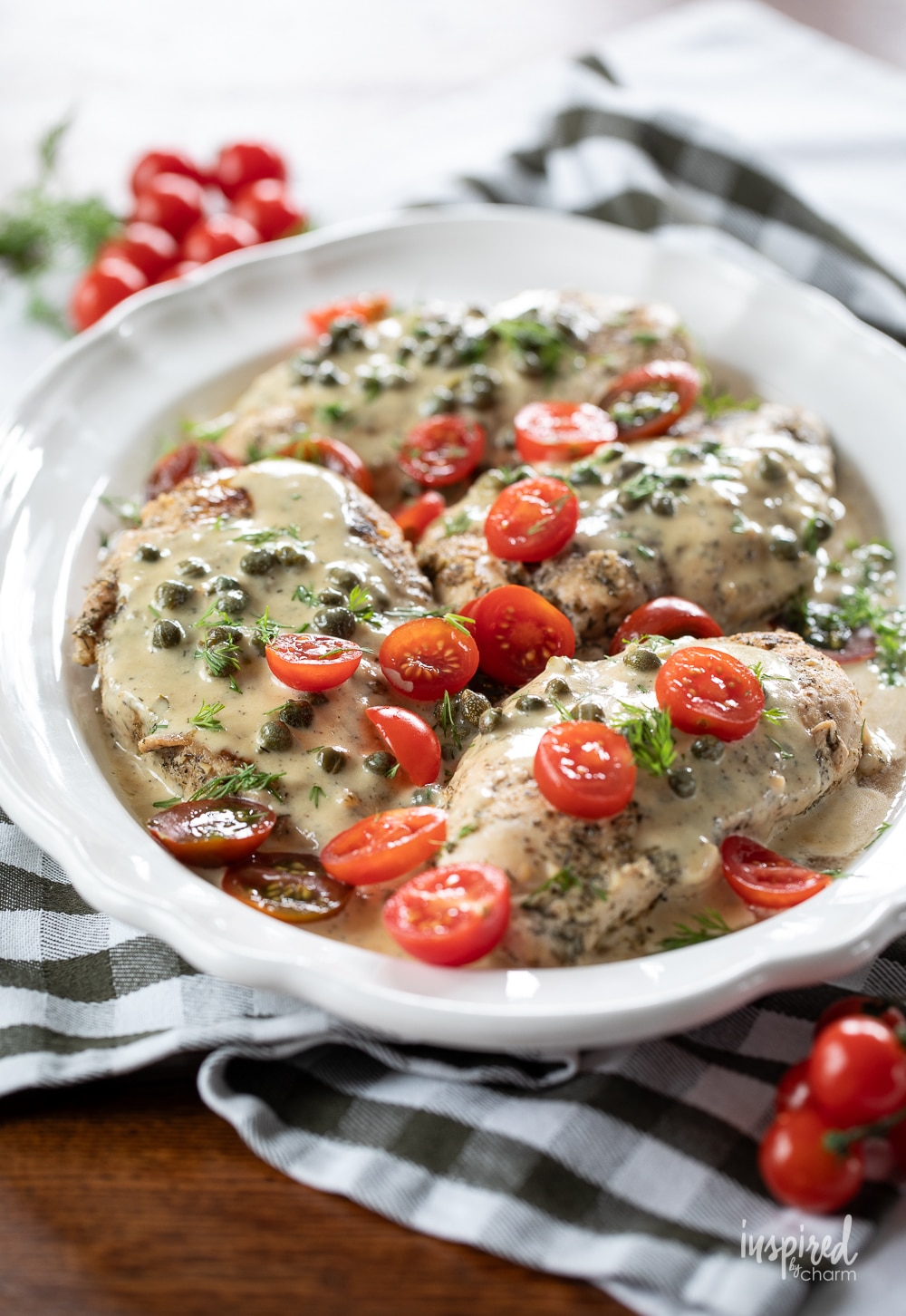 dinner spread with a platter of chicken with caper cream sauce.