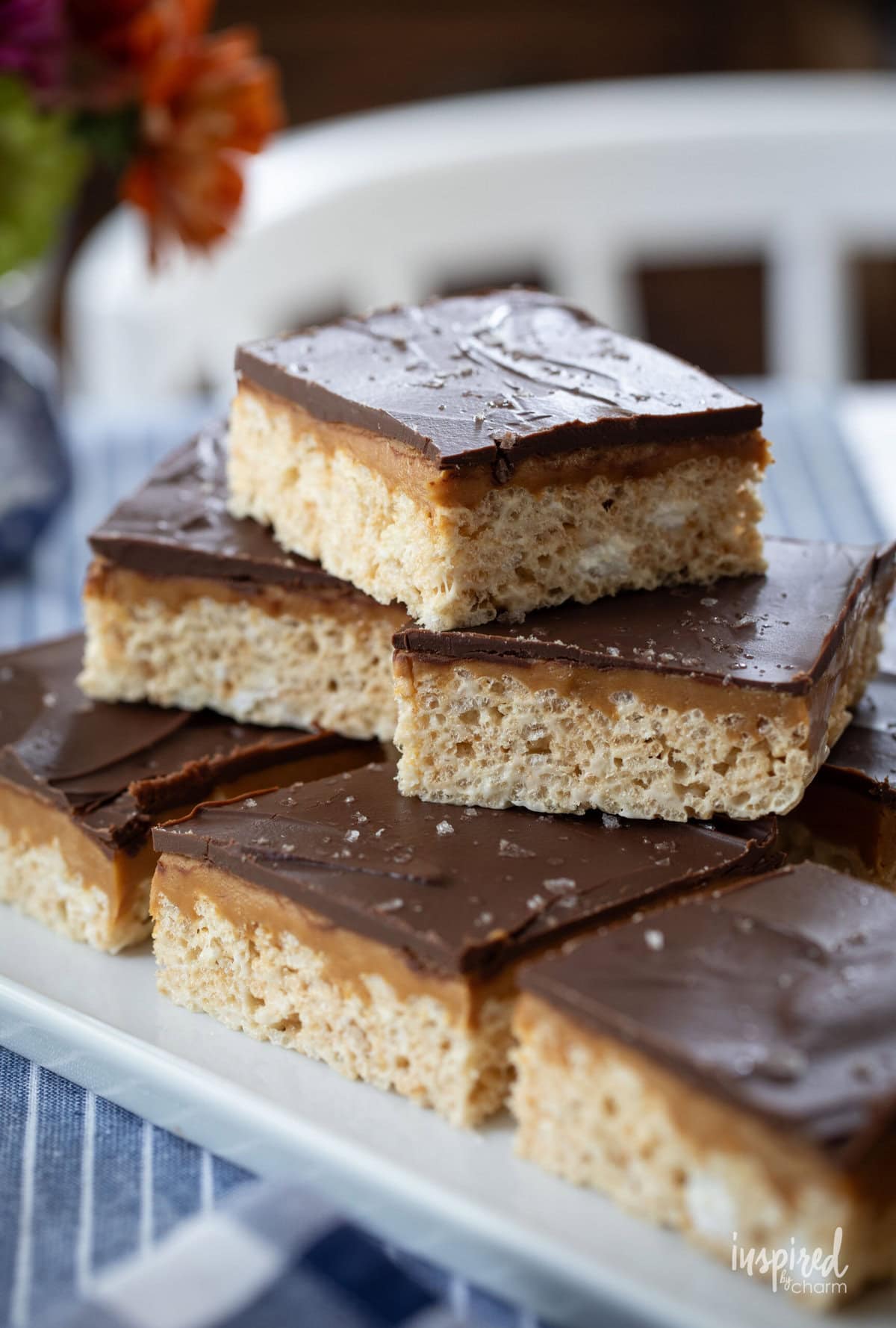 Chocolate Peanut Butter Caramel Cereal Bars stacked on a platter.