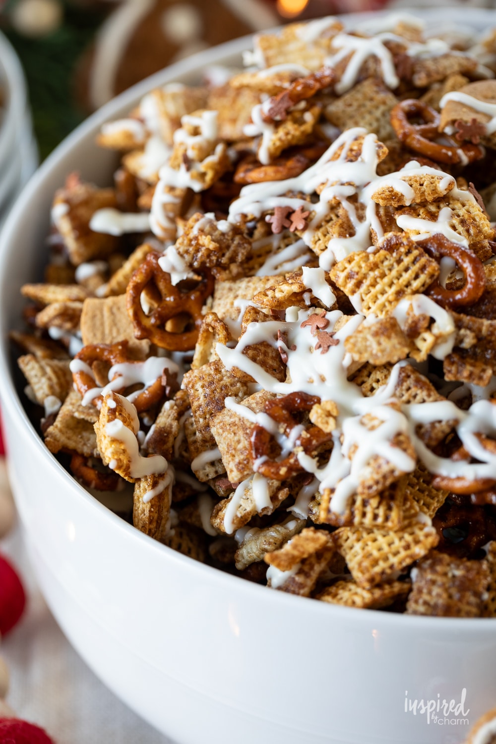 serving bowl filled with festive gingerbread chex mix drizzled with white chocolate.