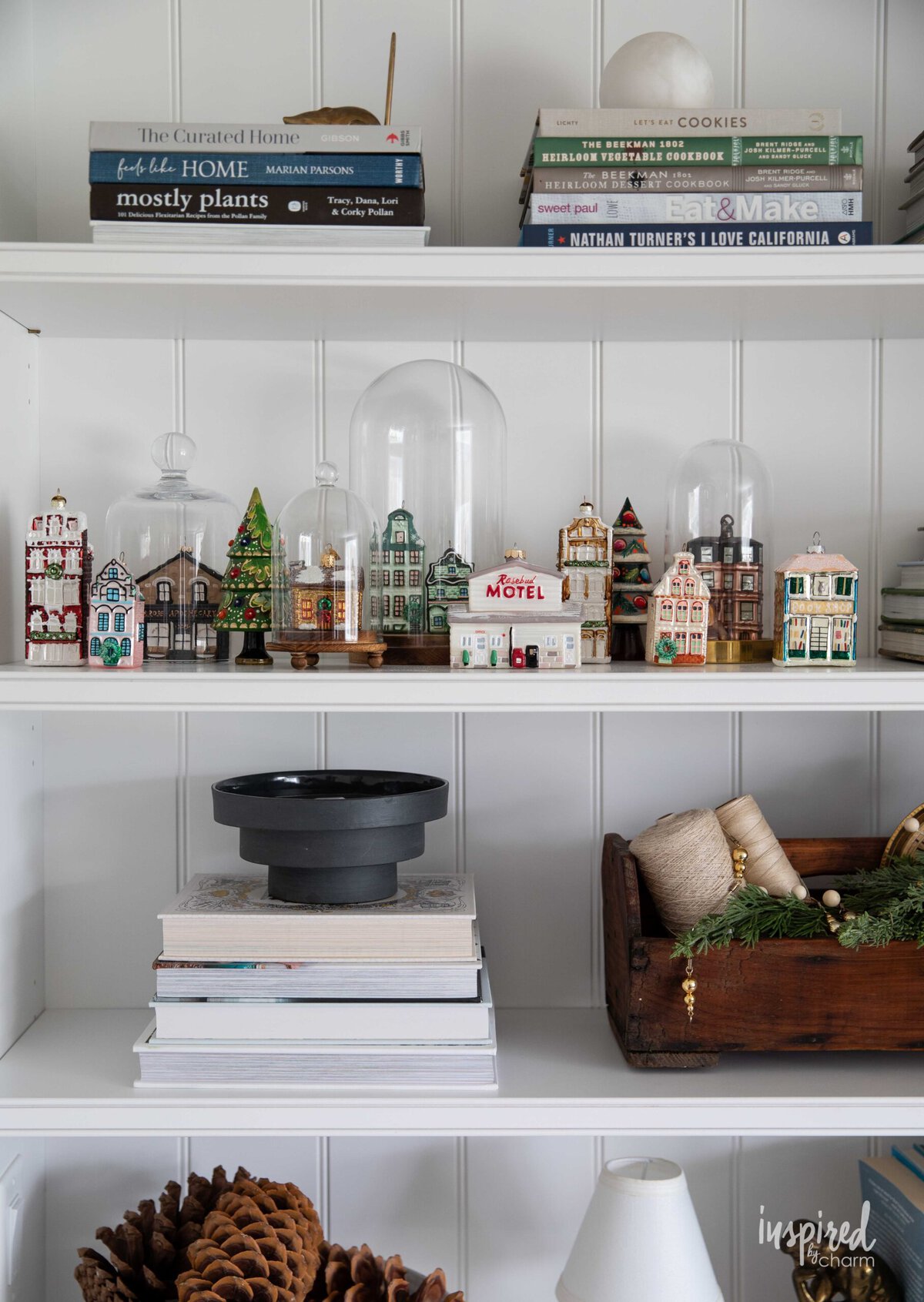 bookcase shelves decorated for Christmas with glass house ornaments.