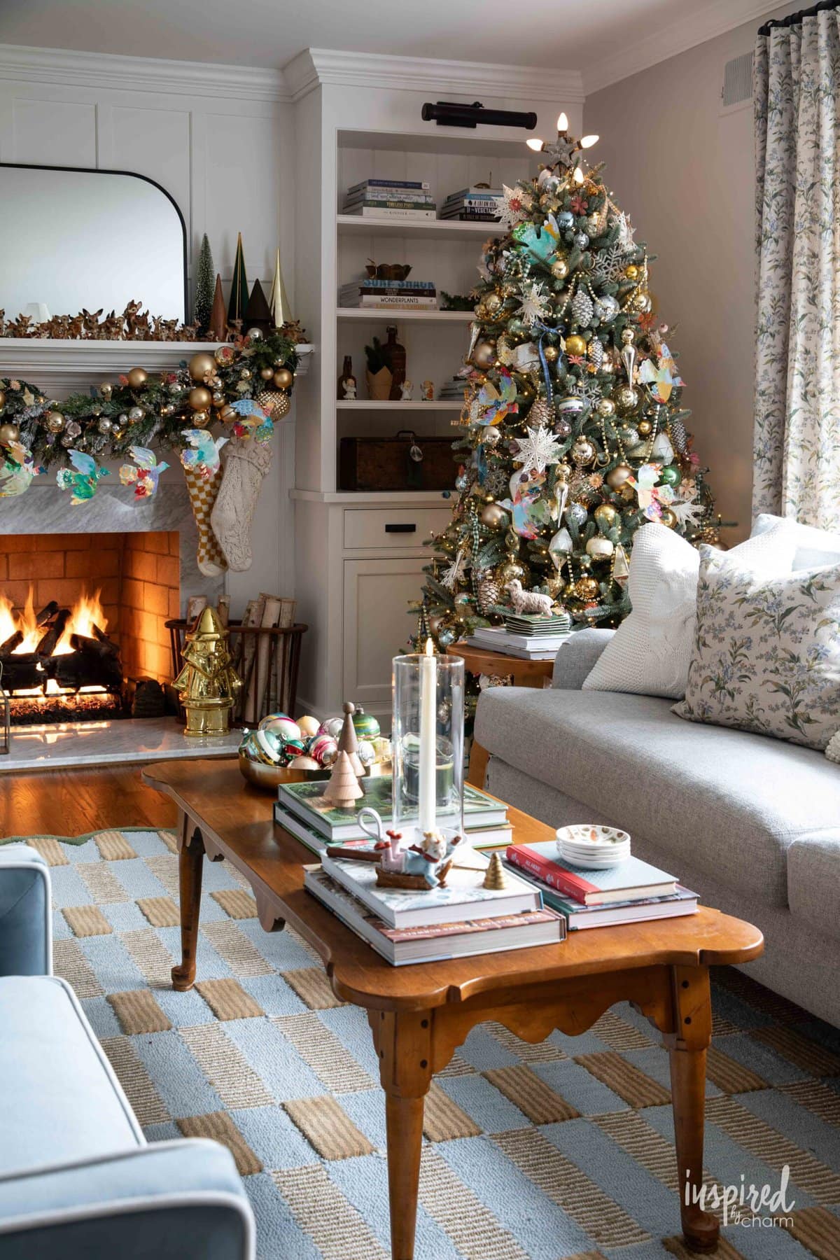 living room decorated for Christmas with tree, garland, and fireplace.