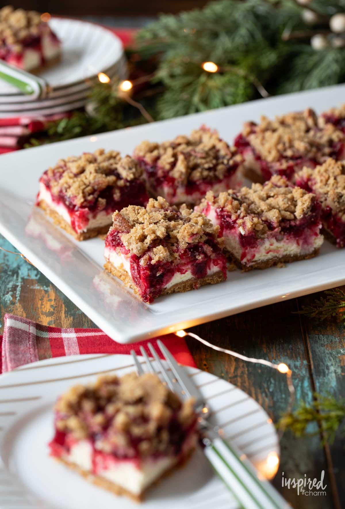 Cranberry Cheesecake Bars on a platter and one served on a plate.