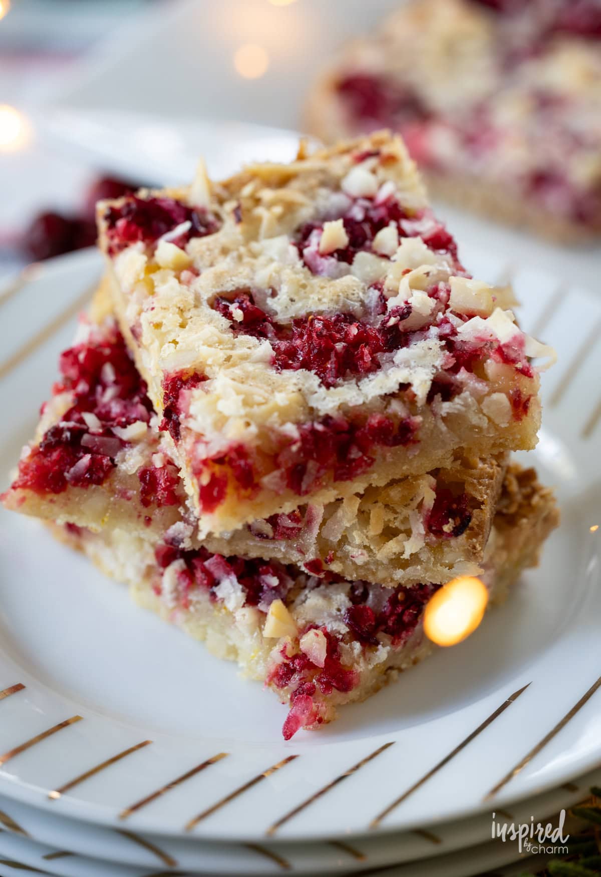 Cranberry Macadamia Coconut Bars stacked on a small plate.