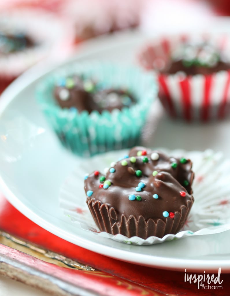 chocolate peanut crock pot candy in an unwrapped paper on a plate.