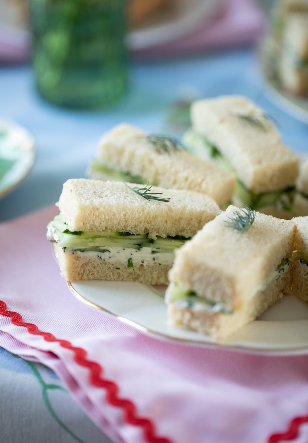 small cucumber finger sandwiches on a plate.