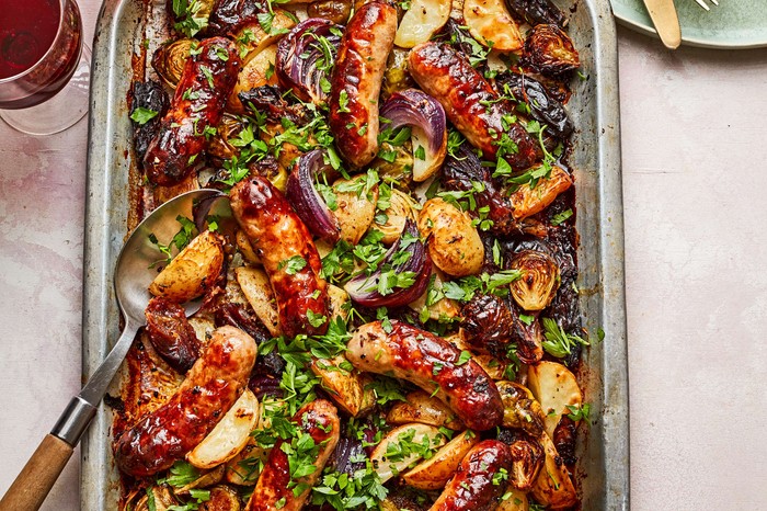 A sausage traybake with a serving spoon in it