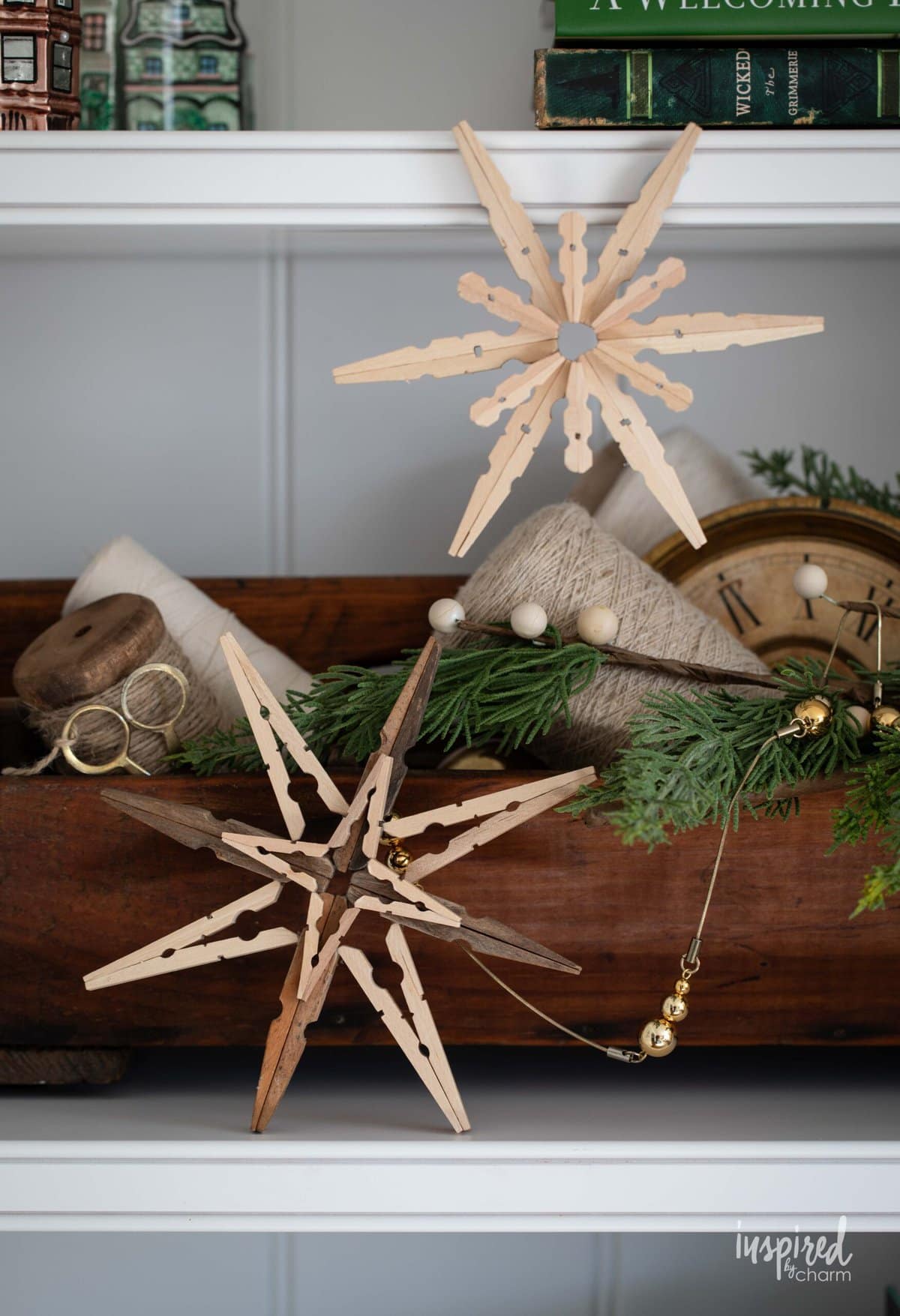 Clothespin Snowflakes on a shelf with Christmas decor.