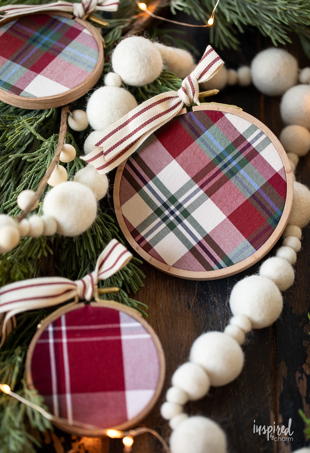DIY Embroidery Hoop Christmas Ornaments on pine with lights and felt garland.