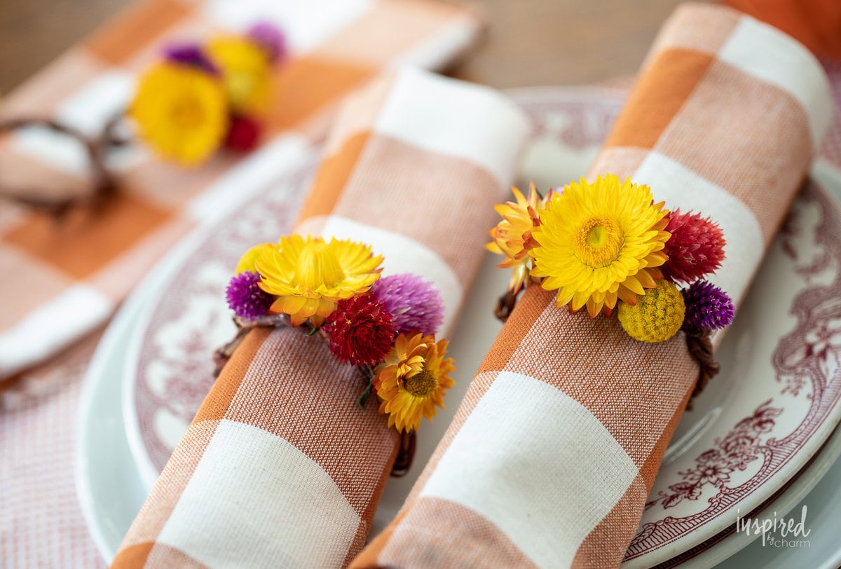 DIY Dried Flower Napkin Rings on napkins on plates.