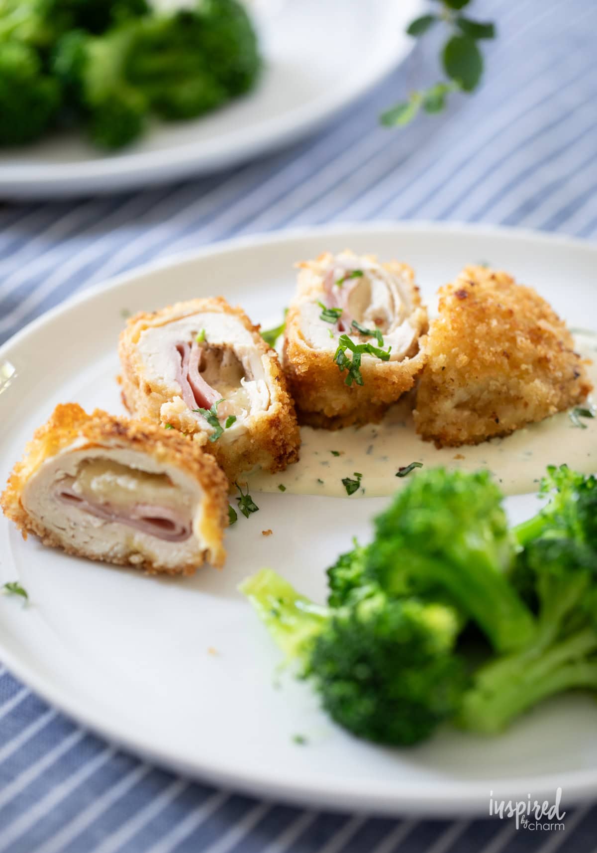 sliced chicken cordon bleu served on a plate with broccoli.