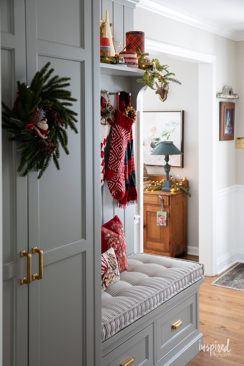 entryway closet and shelves and bench decorated for Christmas.