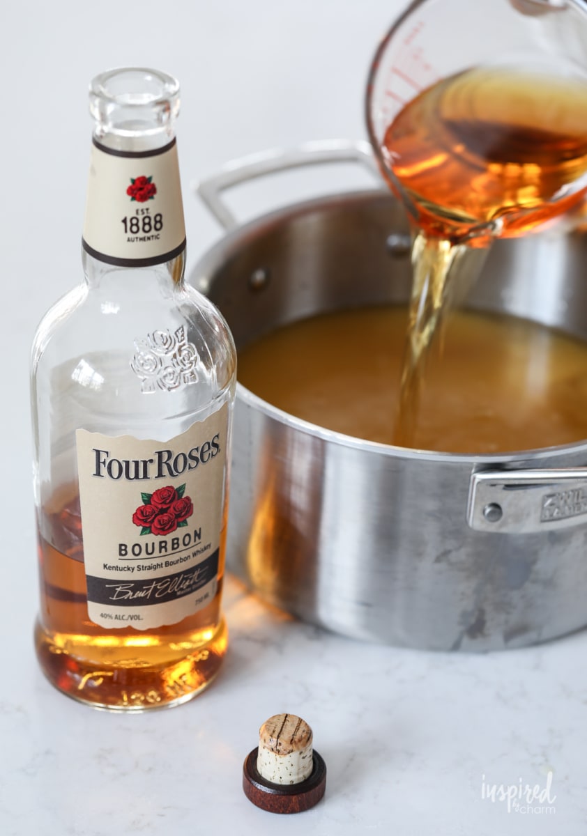 adding bourbon to a pan with Frozen Old Fashioned Slush. 