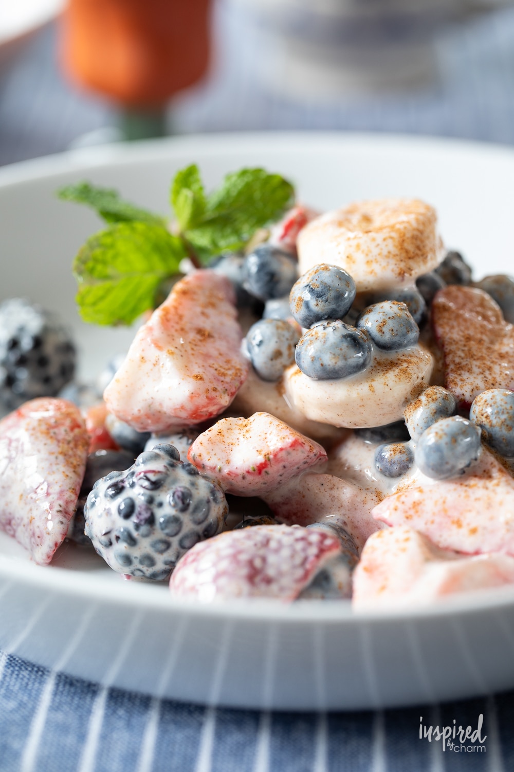 bowl of fruit salad with yogurt and fresh mint.
