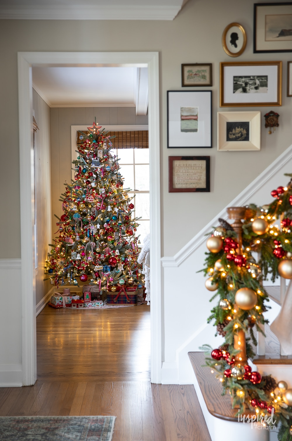 christmas tree in the background of a entryway decorated for christmas.