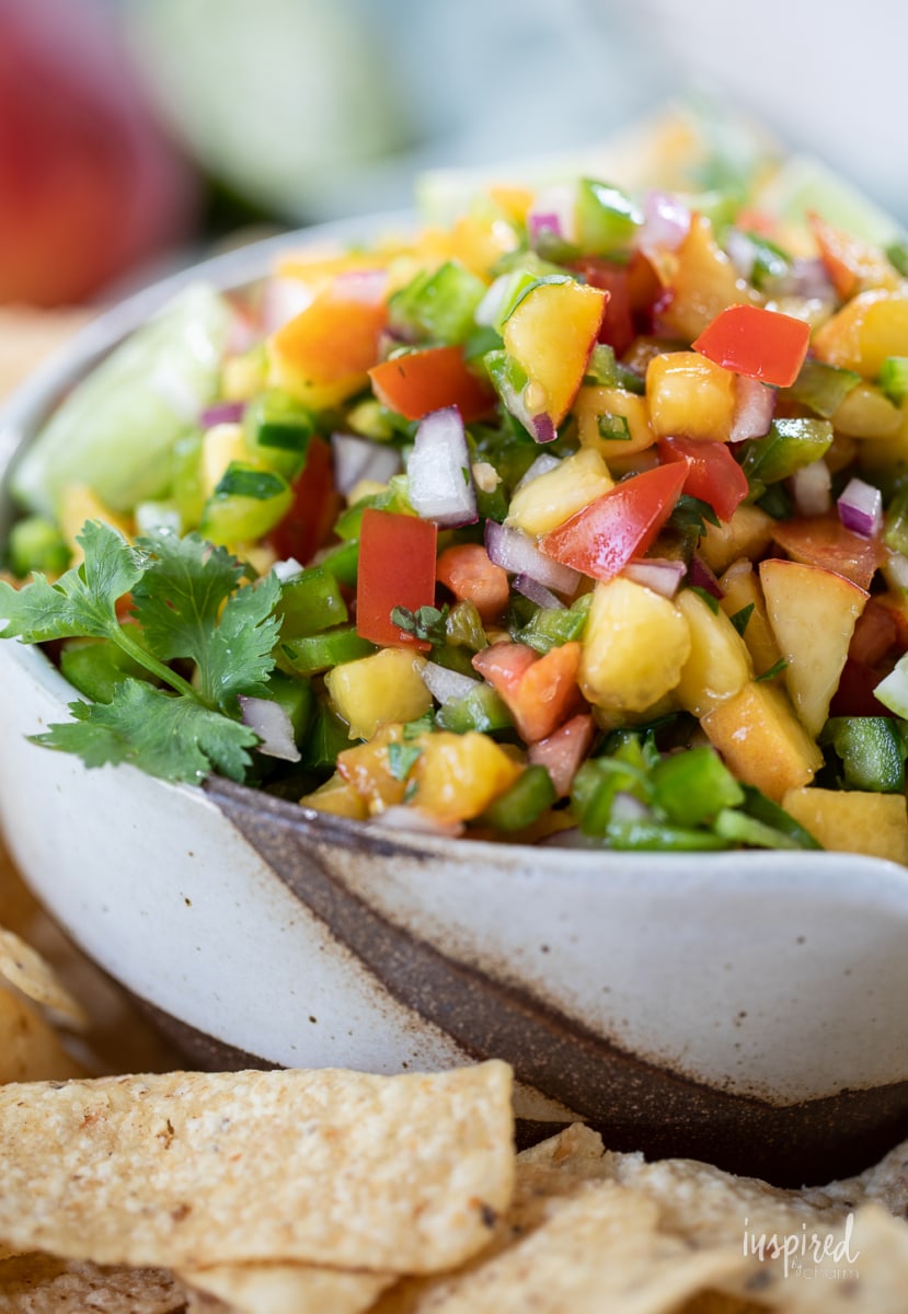 Spicy Peach Salsa in a bowl with tortilla chips.