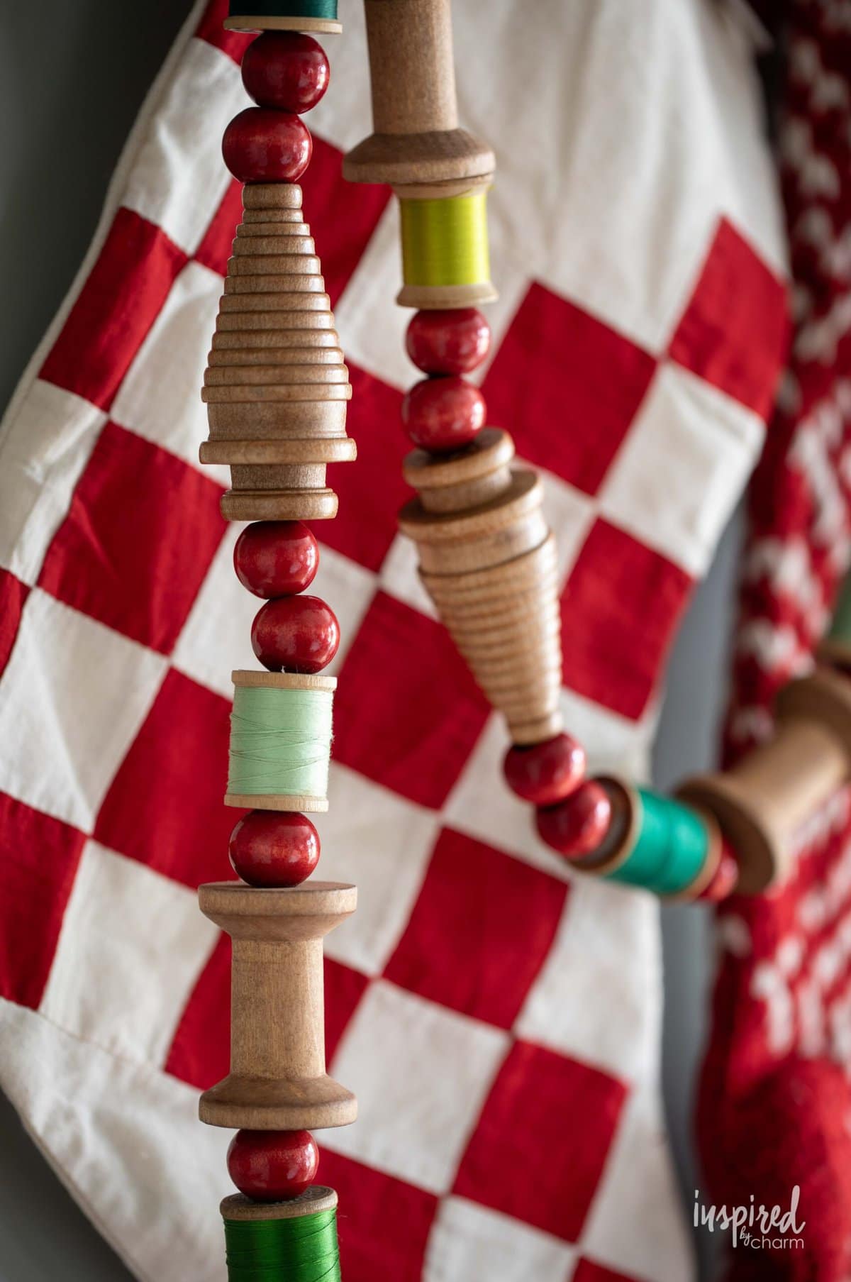 Vintage Bobbin Christmas Garland hung in front of a stocking.