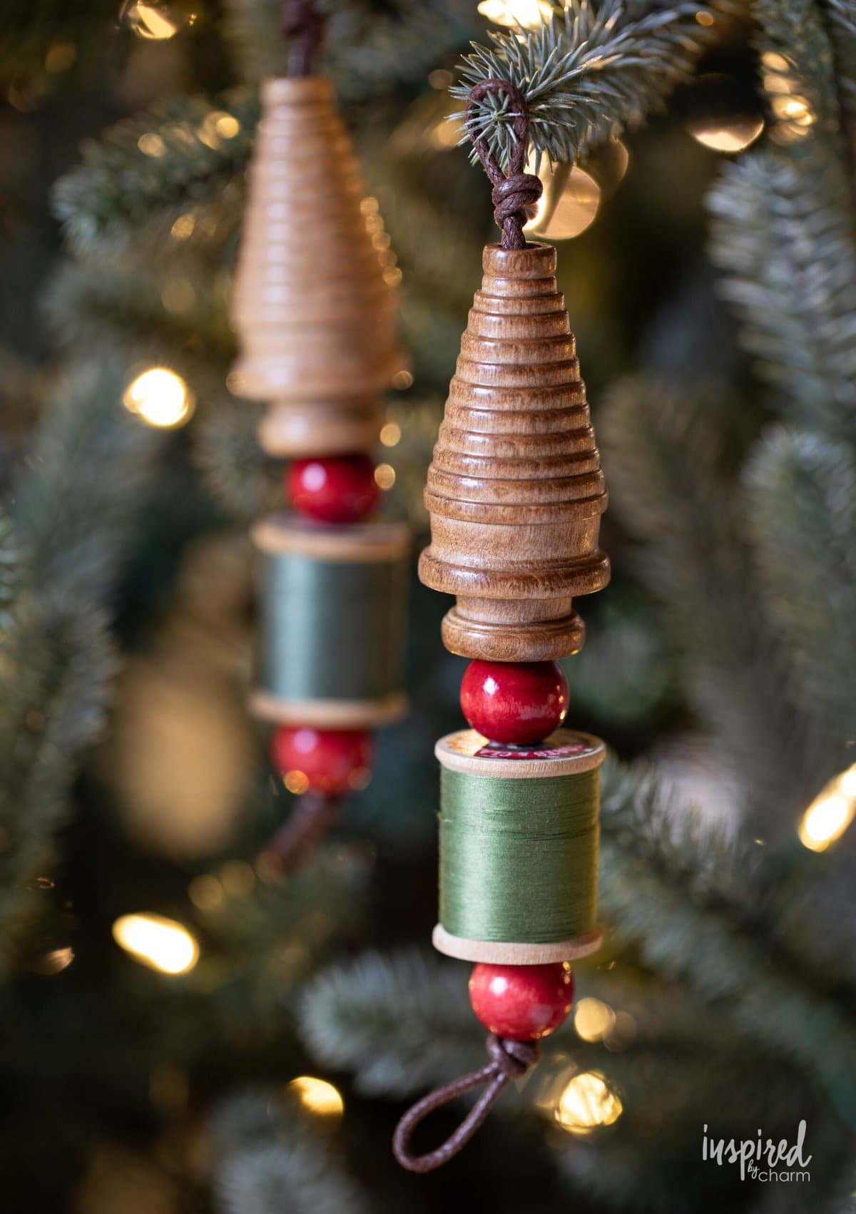 two vintage bobbin christmas ornaments on a tree.