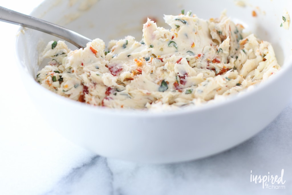 mixing together a bowl of sun-dried tomato butter