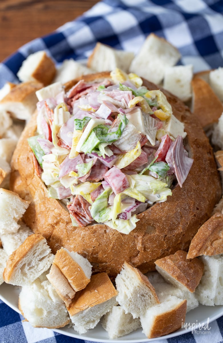 Italian Hoagie Dip in a bread bowl with piece of bread around it. 