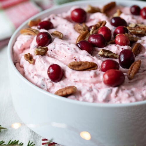 Cranberry Fluff Salad in a bowl garnished with cranberries and pecans.