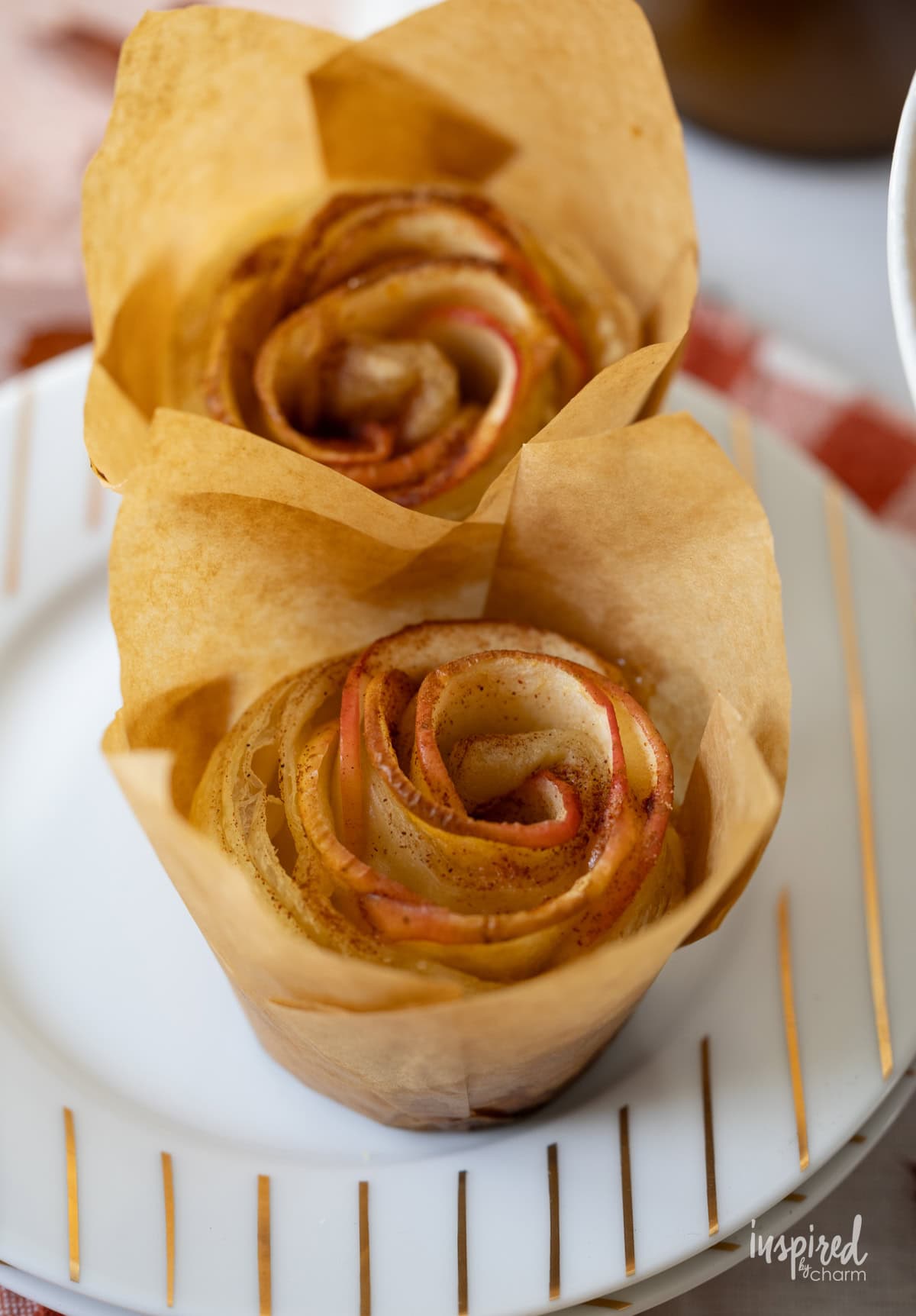 two Apple Puff Pastry Roses on small plate.