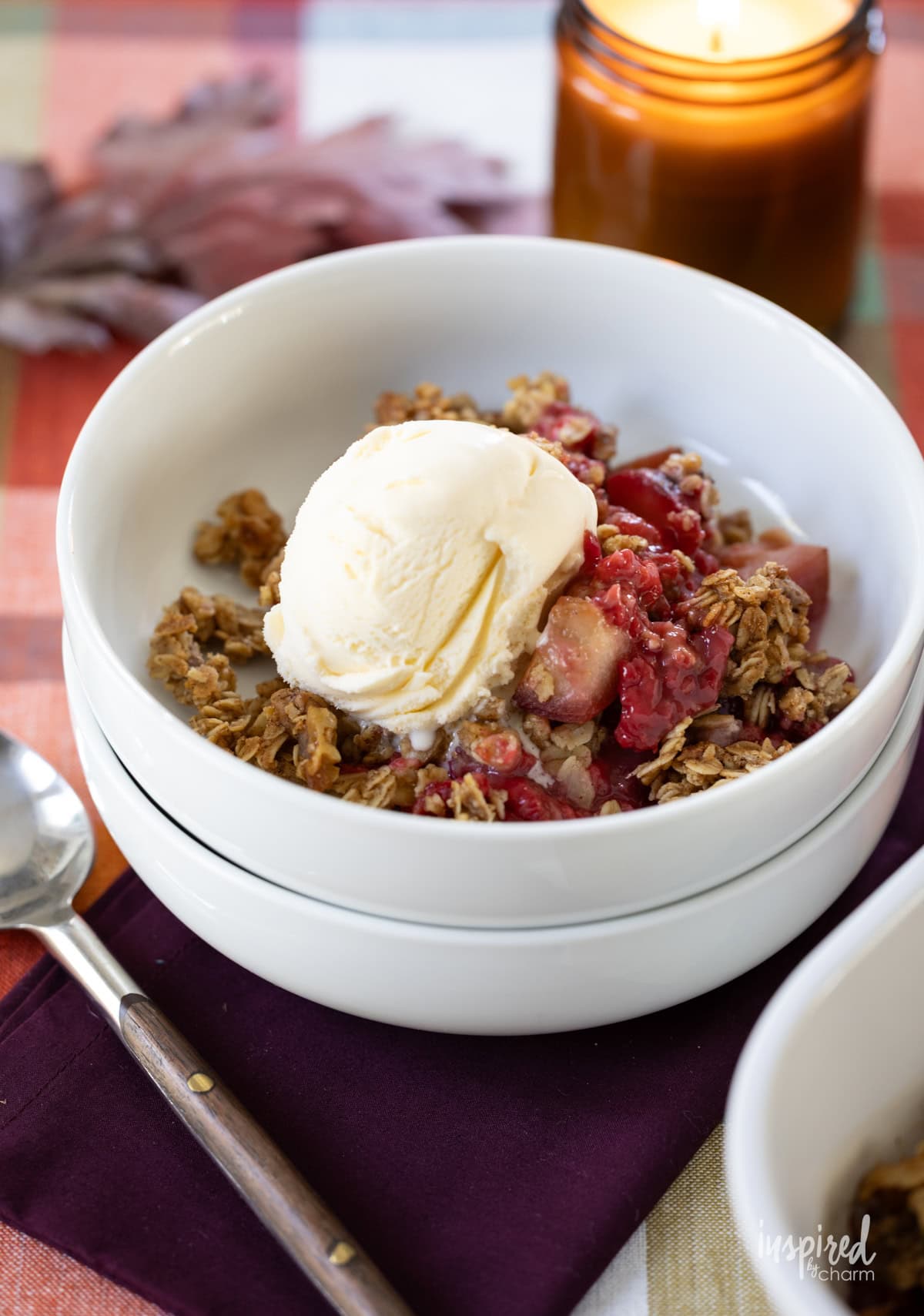 Plum and Raspberry Crisp served in a bowl with ice cream.