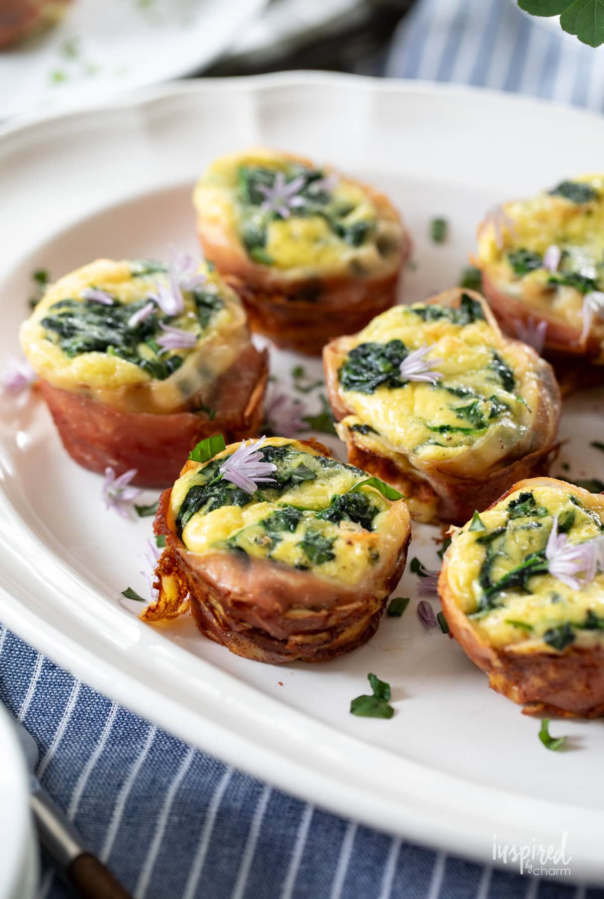 Prosciutto Egg Tarts on a plate garnished with herbs.