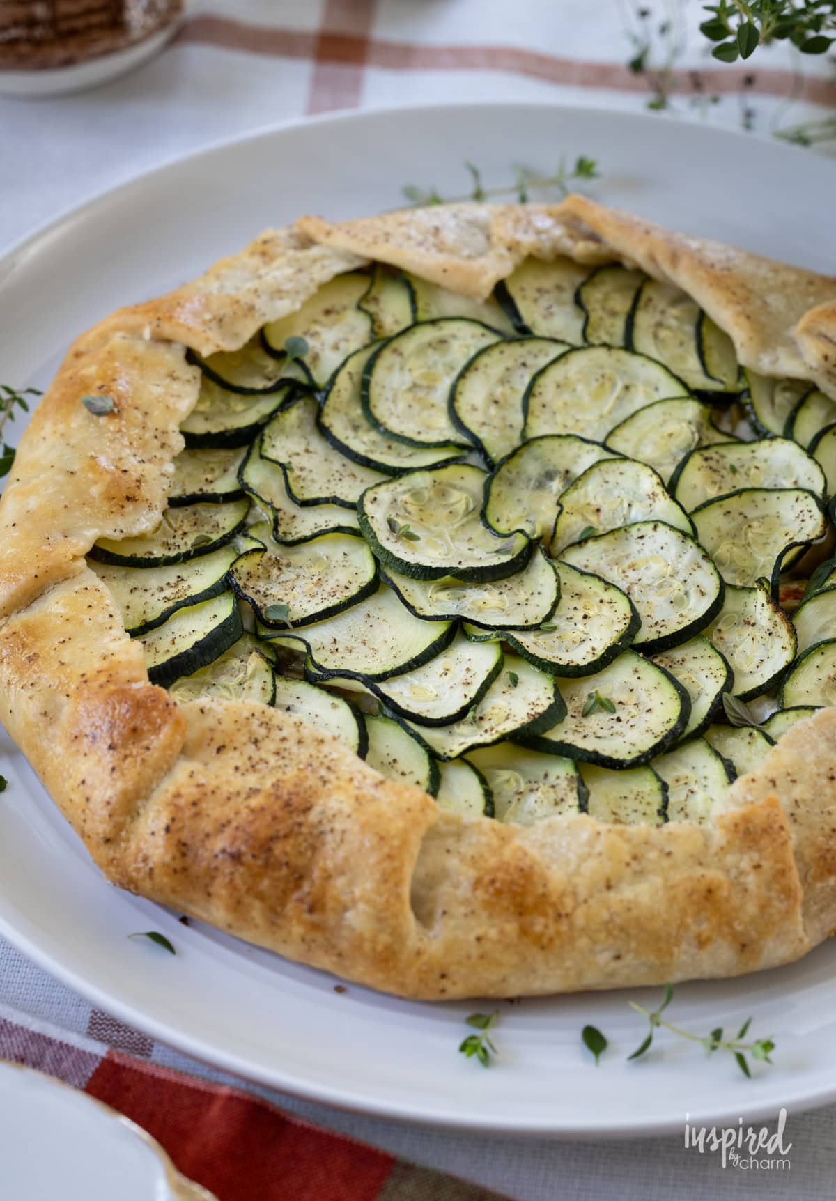 whole zucchini galette on a round white plate.