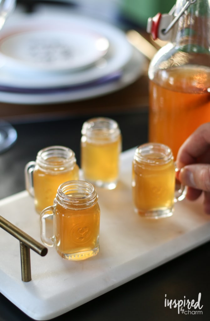 Shot glasses of diy apple pie moonshine.