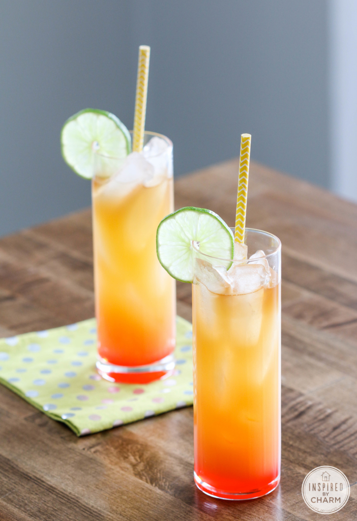 rum punch in a glass with lime wheel and paper straw.