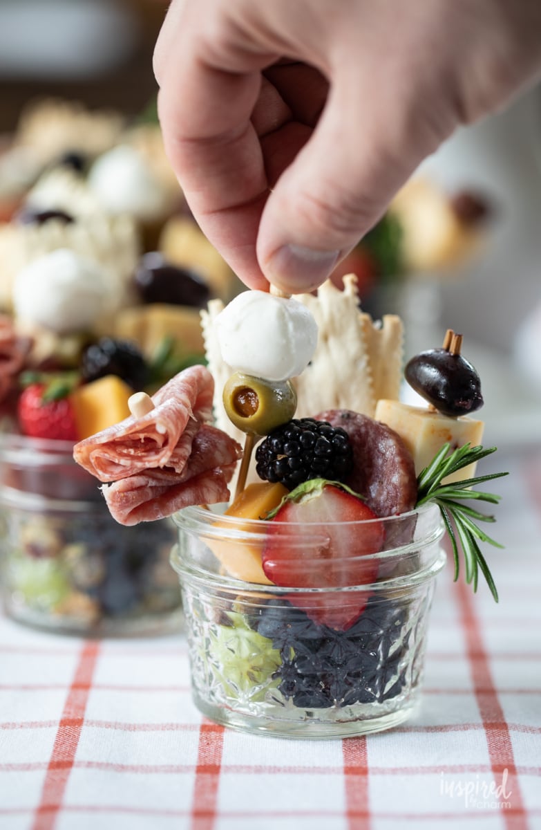 hand putting toothpick into Jarcuterie