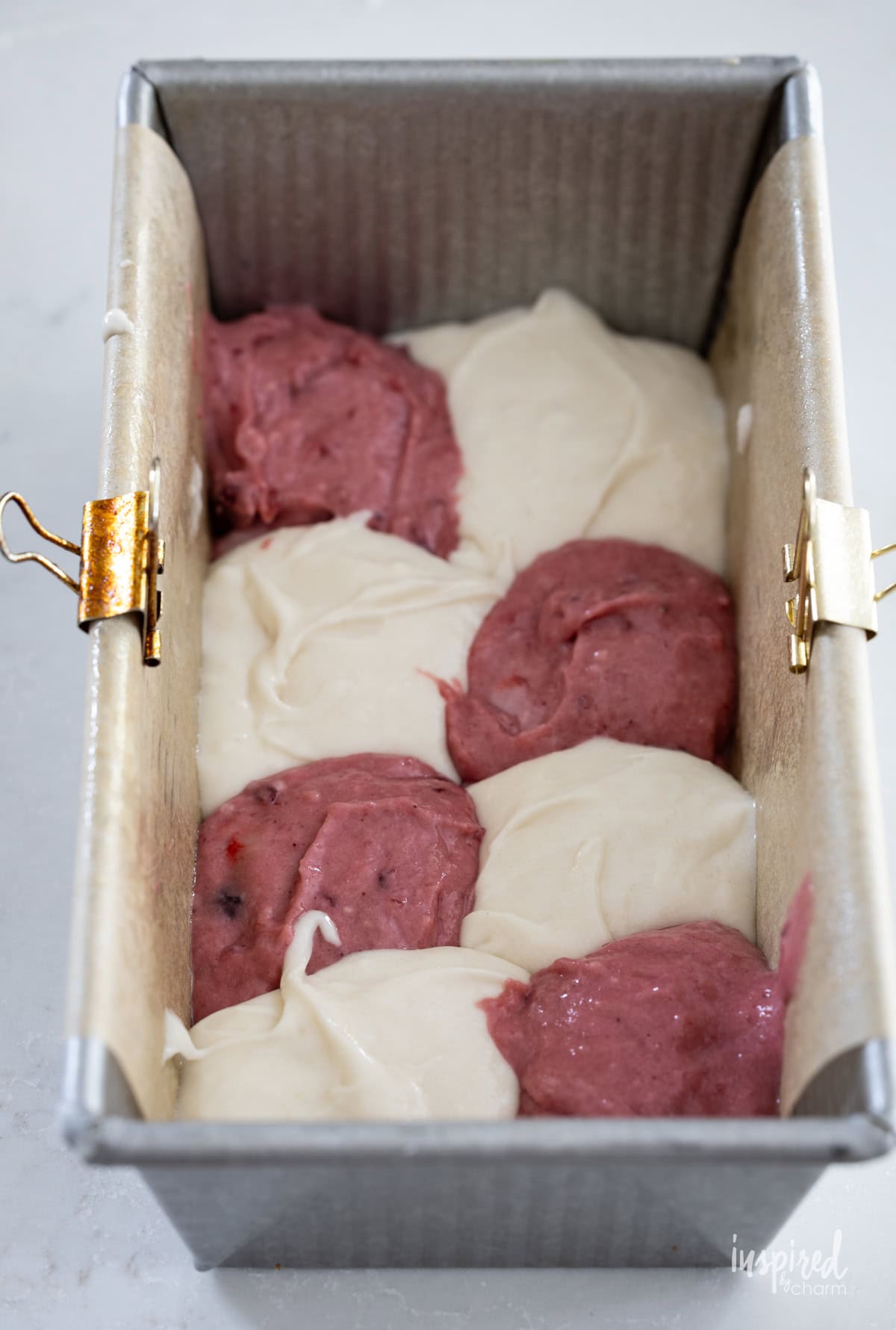batter for Cranberry Marble Loaf Cake checkerboard in a loaf pan.