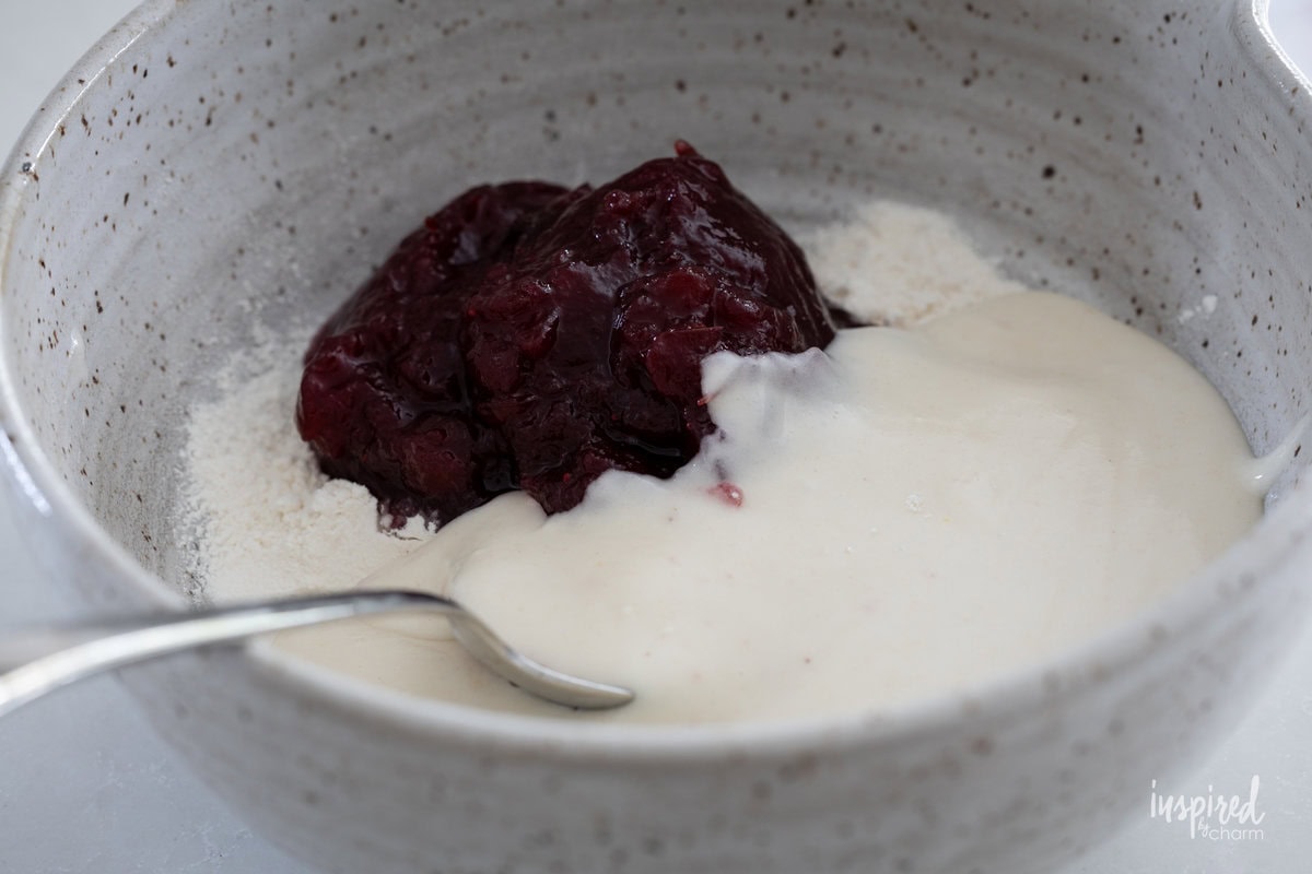 batter for Cranberry Marble Loaf Cake in a bowl with a spoon.