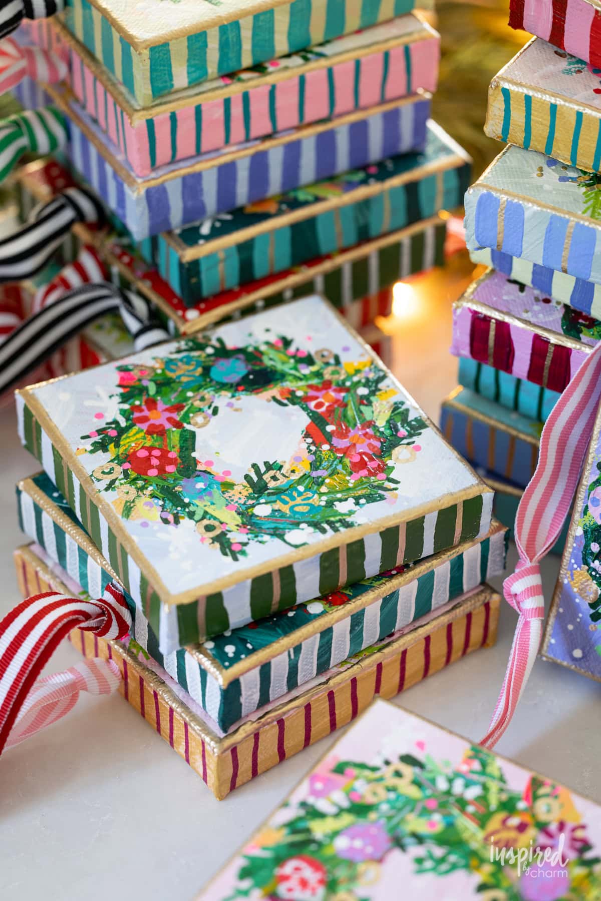 small canvases with festive Christmas wreaths painted on them by Michael Wurm Jr.