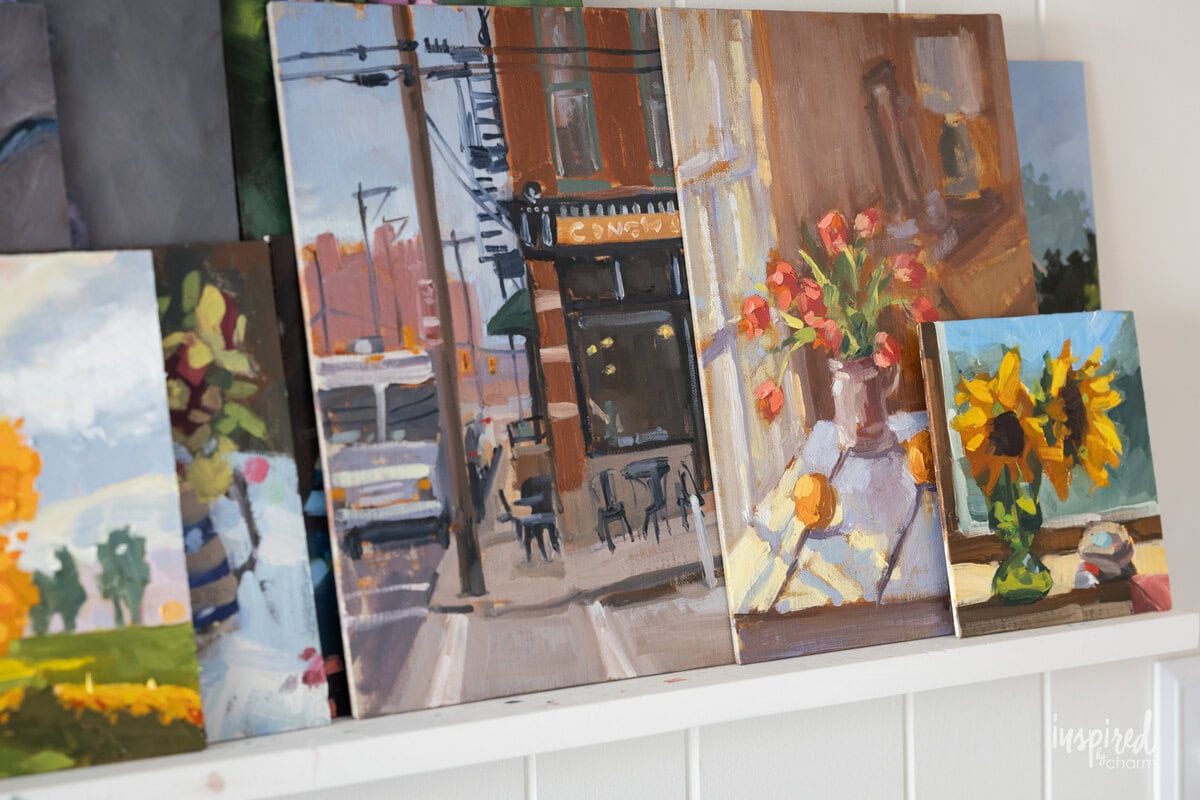 oil paintings by Michael Wurm Jr on a shelf. 