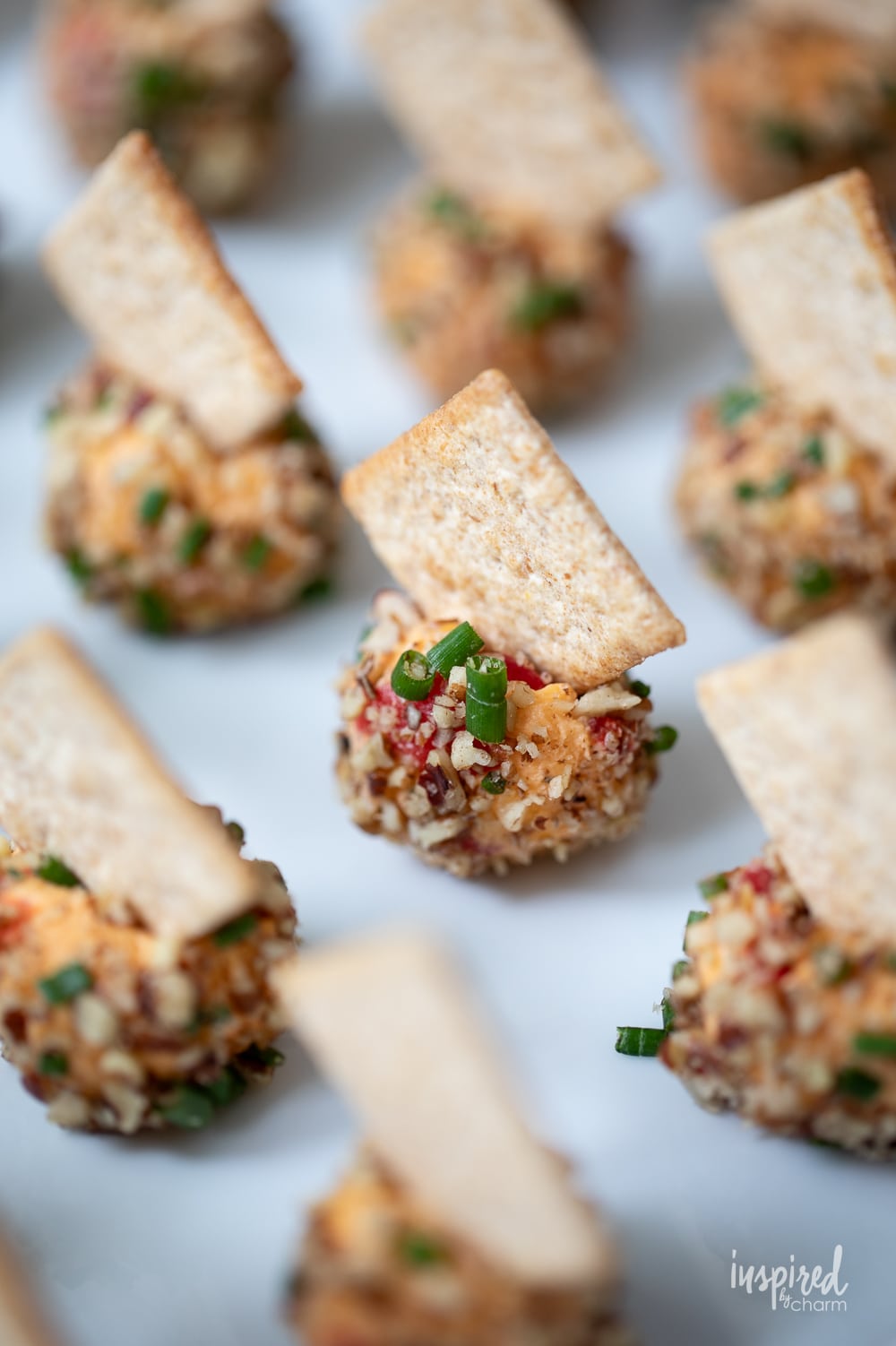close up of mini pimento cheese balls on a white platter.