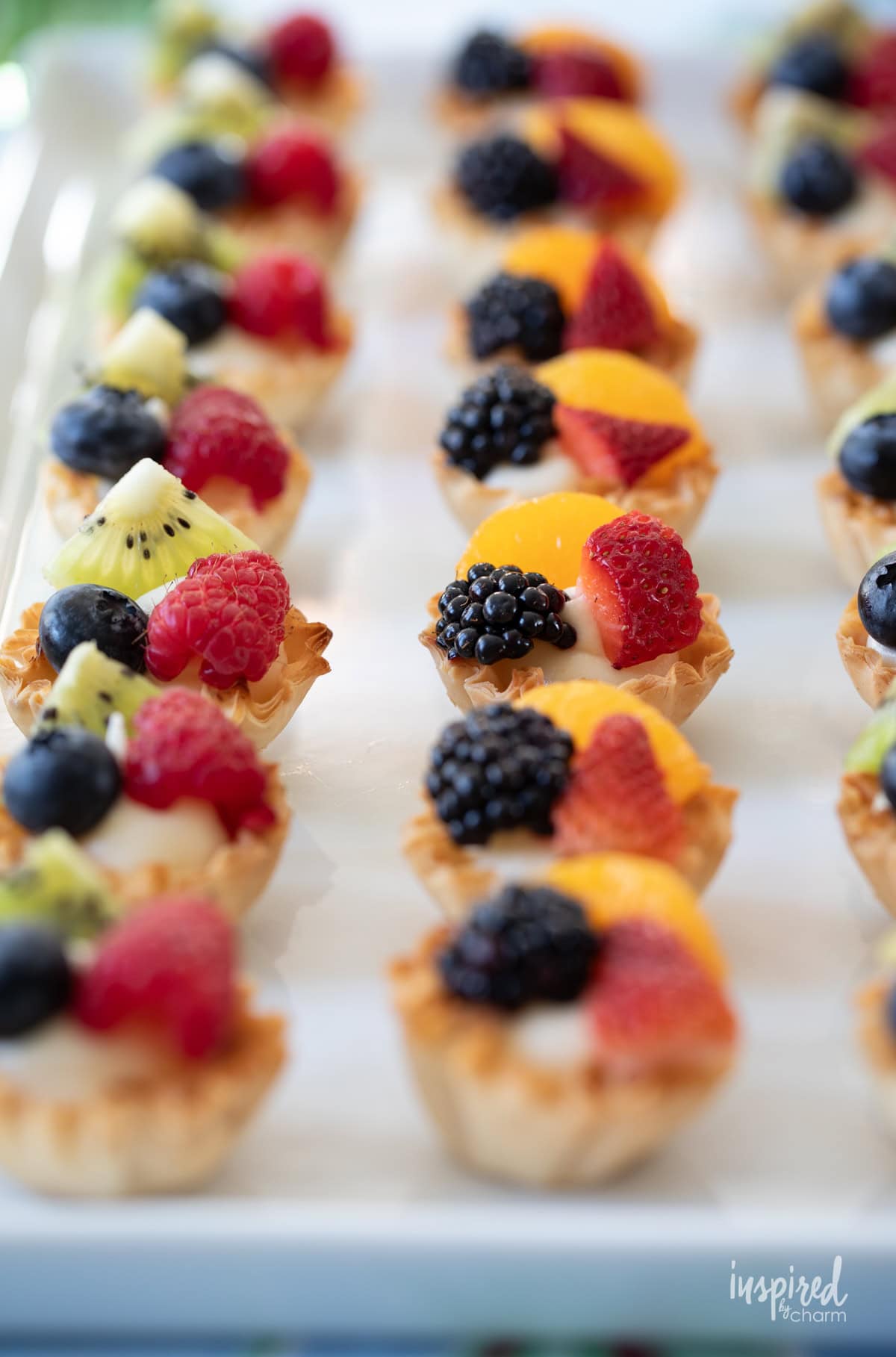 rows of fruit tarts on a platter.