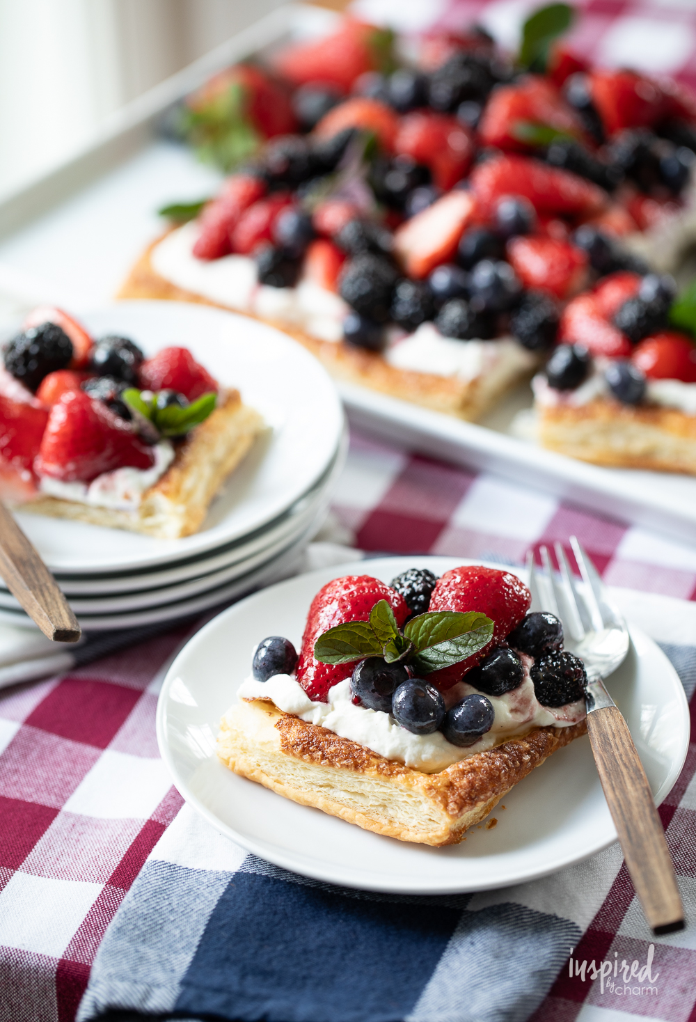 mixed berry fruit pizza on a platter and served on two plates.