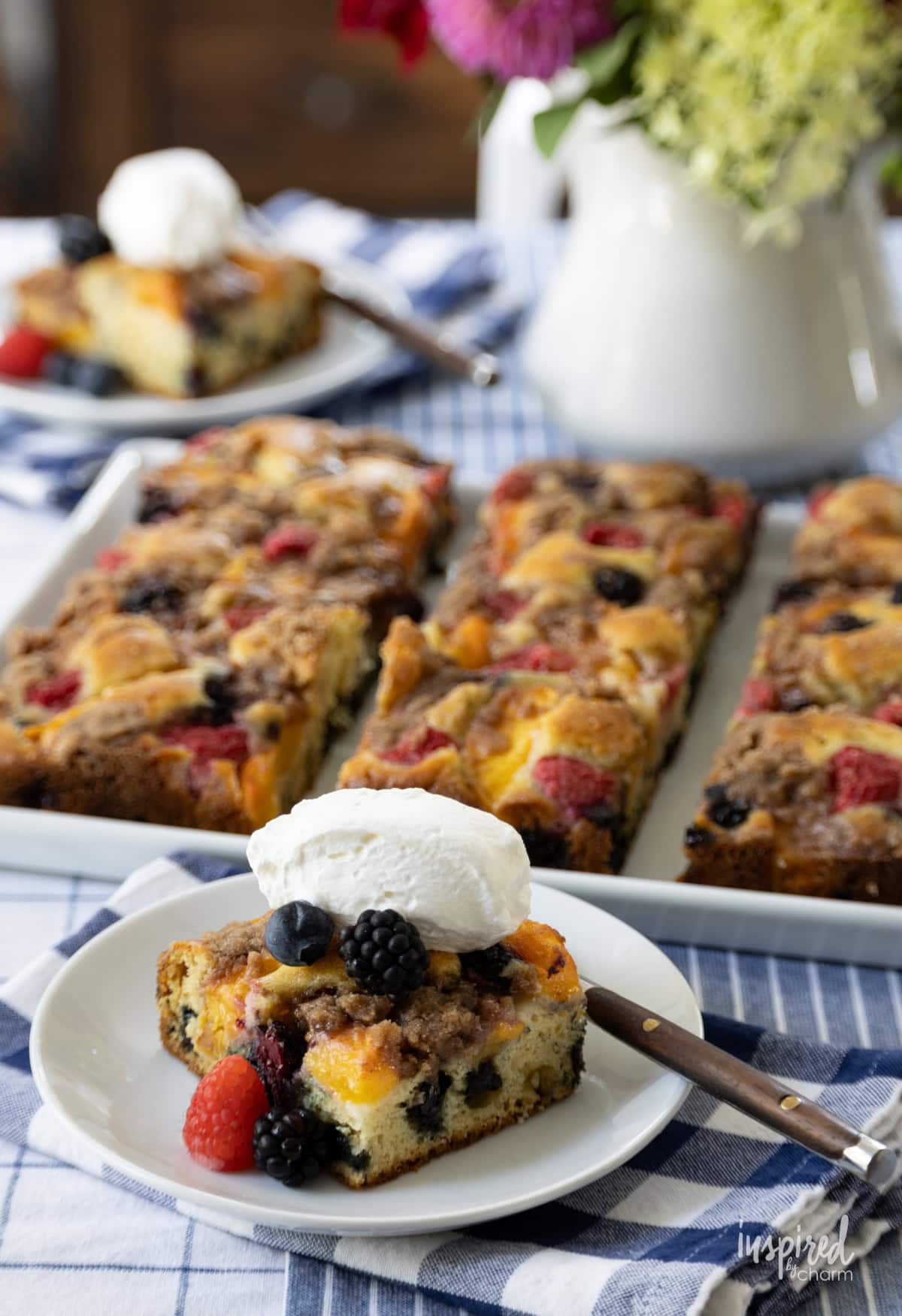 Nectarine and Berry Buckle served on a plate with once piece on a small plate with fork.