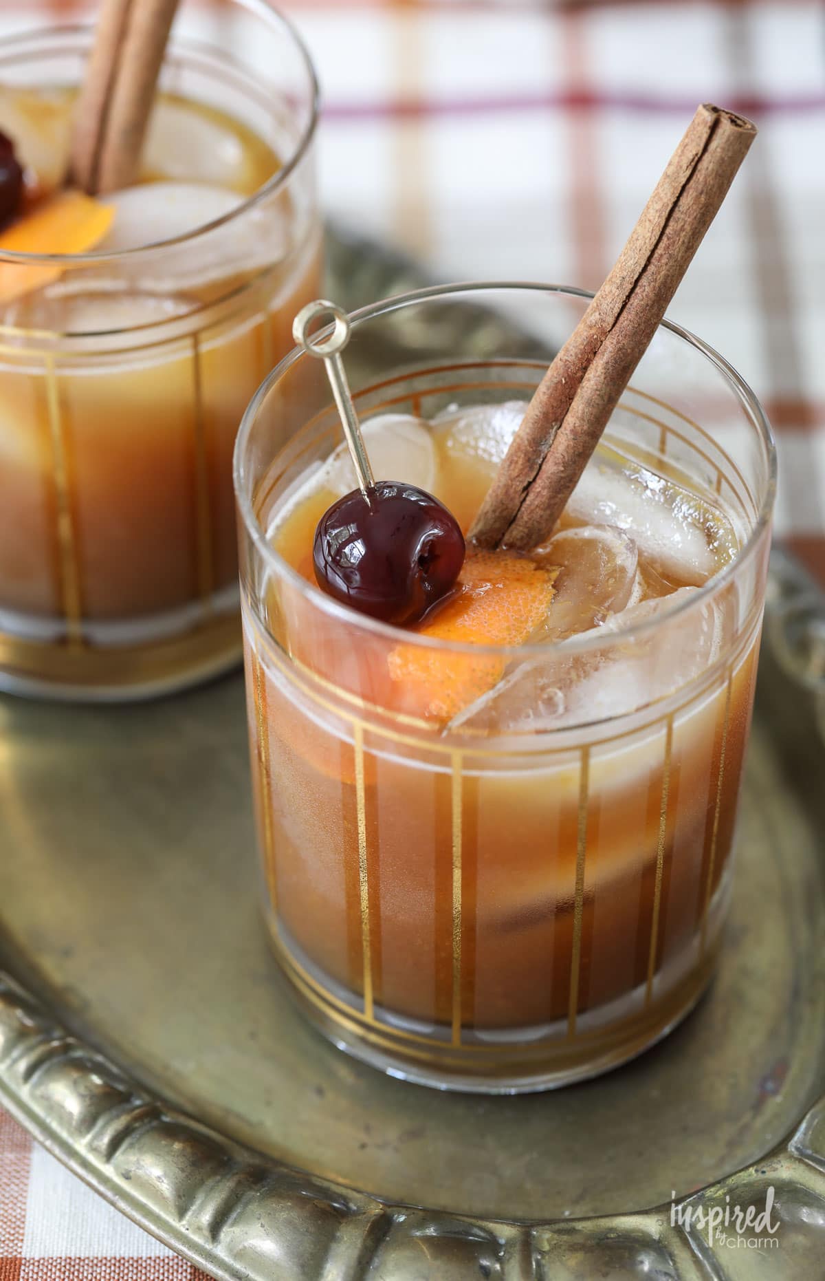Pumpkin Old Fashioned Fall Cocktail with cherry and cinnamon stick garnish.
